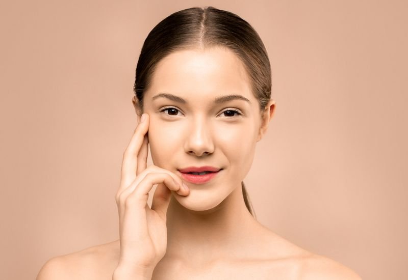Retrato de mulher com pele radiante e viçosa, resultado de tratamento facial revitalizante